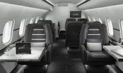 The cabin of a private jet, seats and tables in a club four arrangement